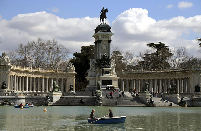 People enjoy the warm weather as they sit in boats during a sunny spring day at Madrid's Retiro park.