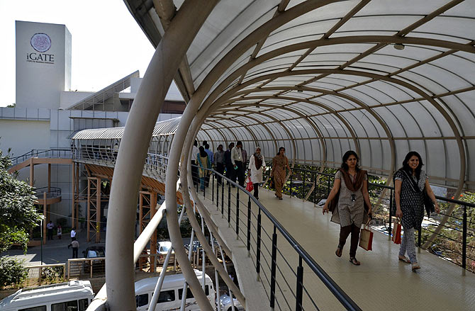 Employees cross an overpass at the Indian headquarters of iGate in the southern Indian city of Bangalore.