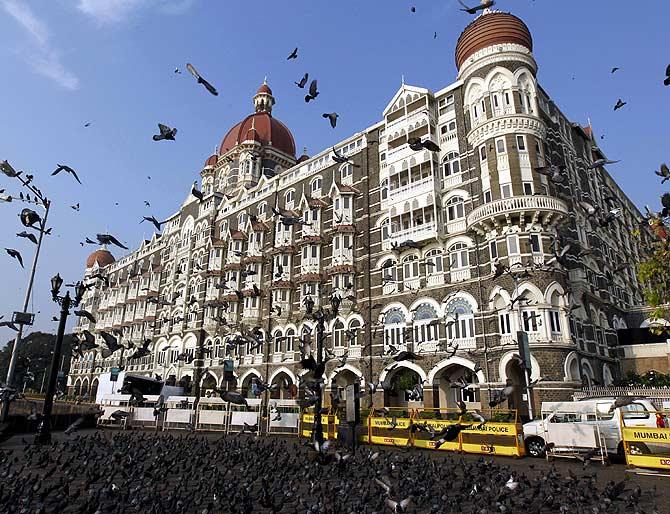 Pigeons fly in front of the Taj Mahal hotel in Mumbai.