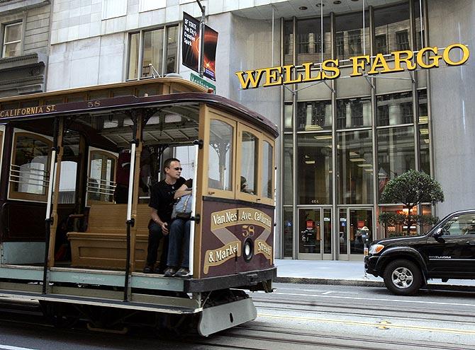 A cable car passes a Wells Fargo bank building along California Street in San Francisco.