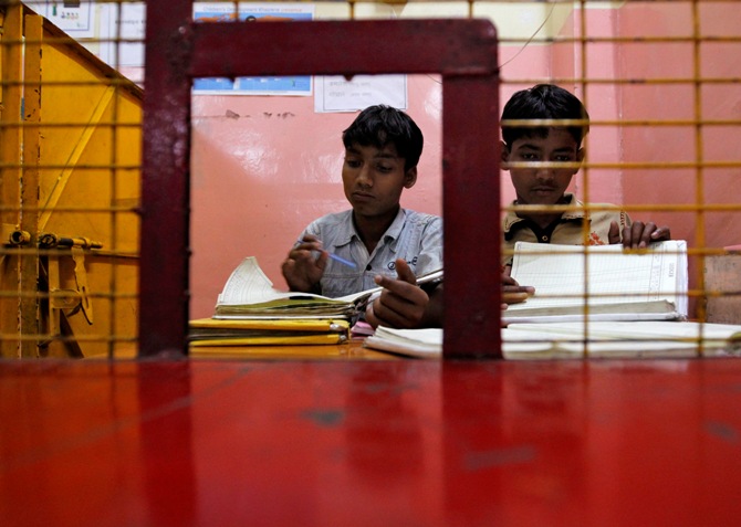 Street children check account books for their customers, also street children, at a bank supported by a local NGO in the old quarter of Delhi.