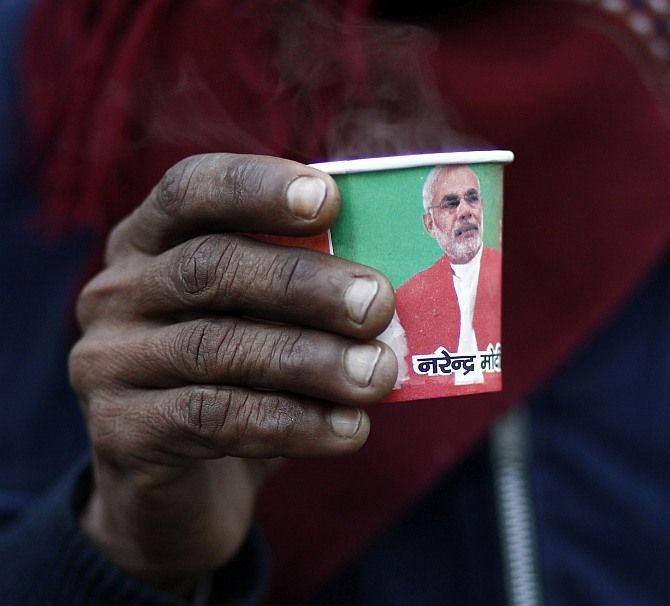 A man holds a paper cup carrying a portrait of Gujarat's chief minister and Hindu nationalist Narendra Modi, the prime ministerial candidate for India's main opposition Bharatiya Janata Party.