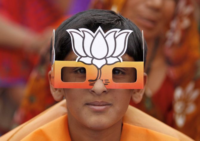 A boy wearing paper goggles featuring a lotus attends an election campaign rally addressed by Hindu nationalist Narendra Modi.