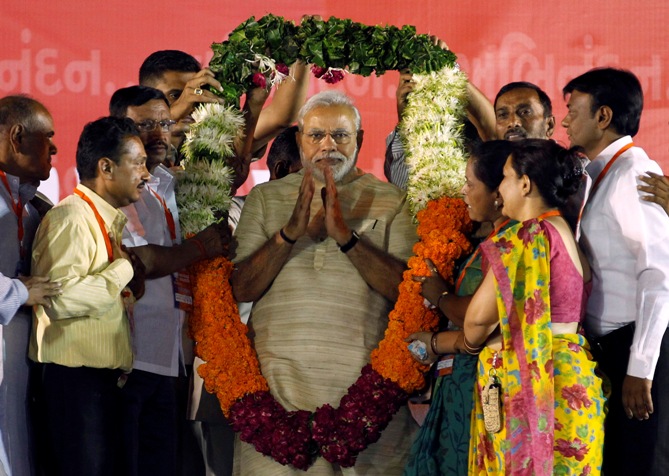 Prime Minister-designate Narendra Modi wears a garland presented to him by his supporters at a public meeting in Ahmedabad.