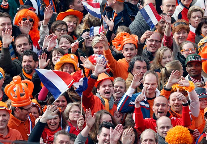 People wave hands as they celebrate the new King Willem-Alexander who succeeds his mother Queen Beatrix, in Amsterdam's Dam Square.