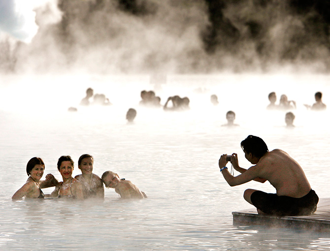 Bathers pose for a photo as they swim in the geothermal hot springs at Iceland's Blue Lagoon near Grindavik.