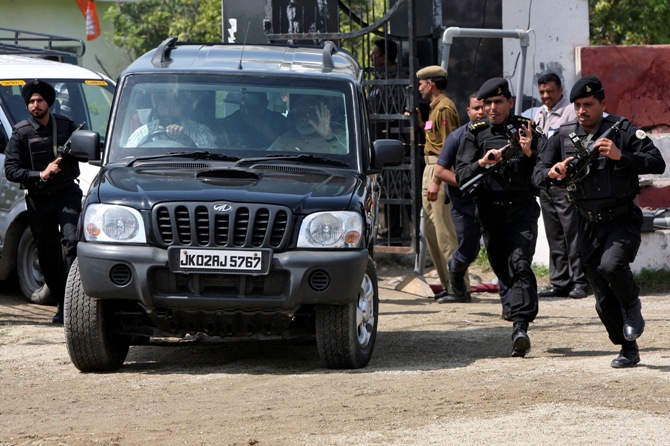 Security personnel of Prime Minister Narendra Modi run next to a car carrying Modi, upon his arrival to address a rally.