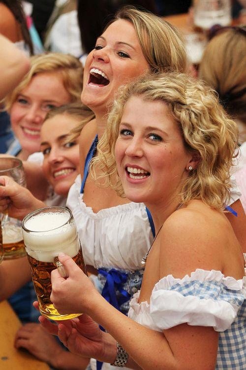 Girls toast with beer mugs during the opening day of the Oktoberfest at Theresienwiese.