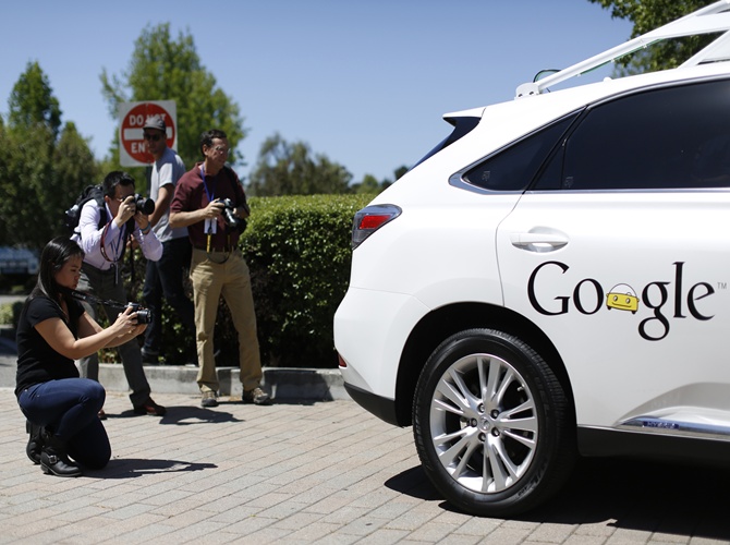 Members of the media take photos of a Google self-driving vehicle at the Computer History Museum after a presentation in Mountain View, California.