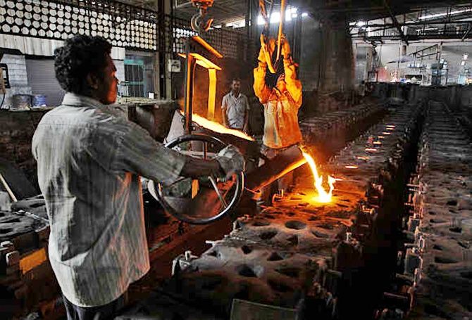 Workers tend to a furnace at a steel factory. 