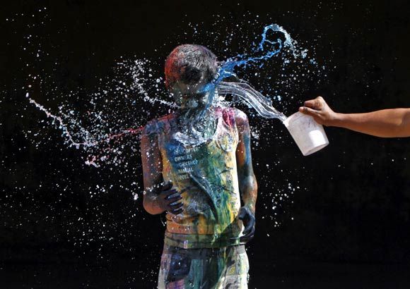 A man is splashed with colours during Holi