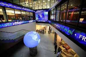 Financial data and news headlines stream accross ticker screens around the atrium of the London Stock Exchange.