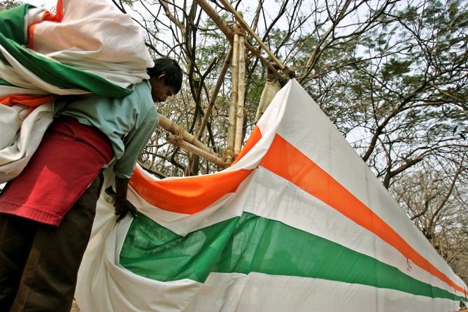A labourer removes tri-coloured curtain after the Republic Day parade in Kolkata. Photograph: Parth Sanyal/Reuters