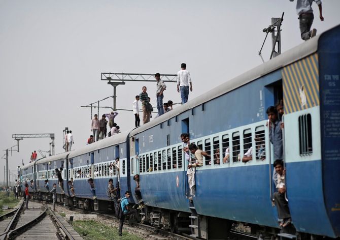 Passengers stand on top of an overcrowded train at Loni town in Uttar Pradesh.
