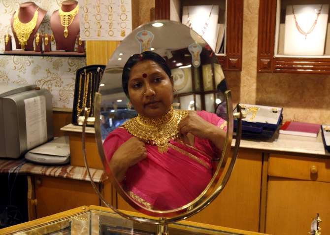 A woman tries a gold necklace.