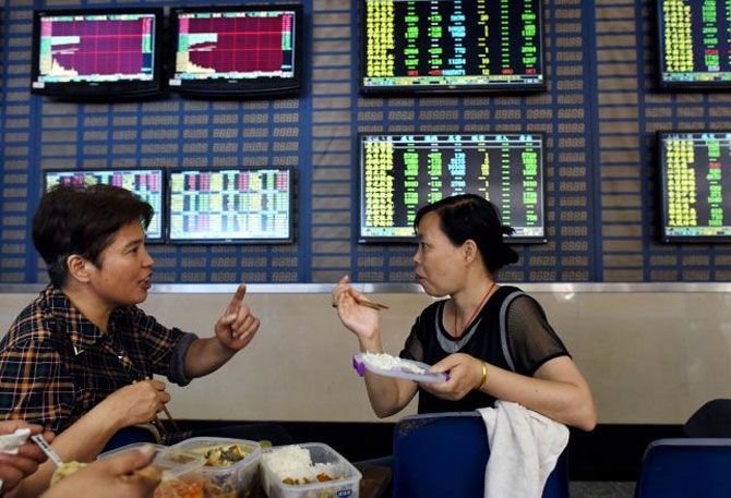 Investors have a meal in front of screens showing stock information, at a brokerage house in Hefei, Anhui province, China, July 8, 2015. Photograph: Reuters