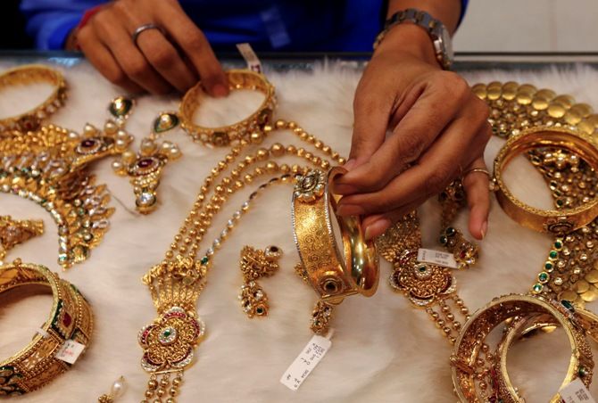 A woman looks at a gold bangle inside a jewellery showroom at a market in Mumbai