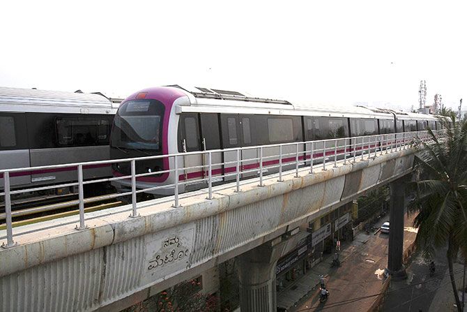 A Namma Metro (Kannada for "Our Metro") train travels along an elevated track in the Indira Nagar area of Bengaluru
