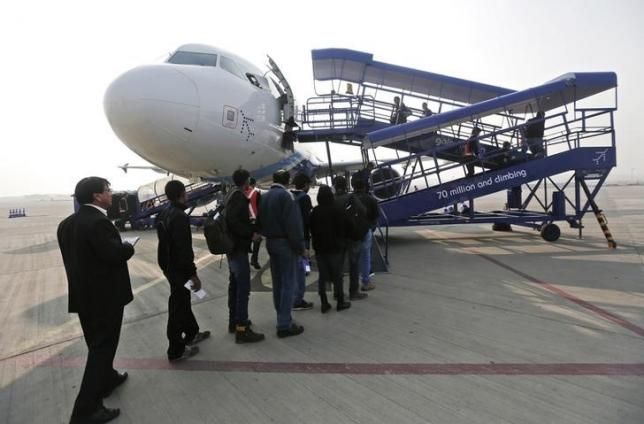 Passengers stand in a queue to board an Indigo Airlines' flight bound for New Delhi at the Srinagar airport. 