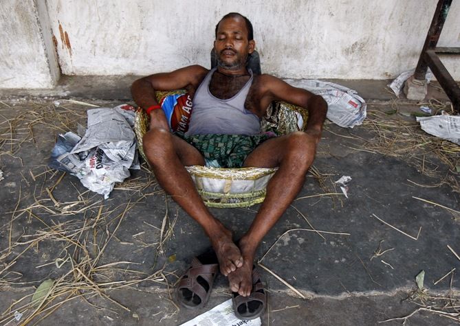 Image: A labourer takes a nap in a basket at a wholesale vegetable market on a hot summer day in Kolkata, May 25, 2015. Photograph: Rupak De Chowdhuri/Reuters