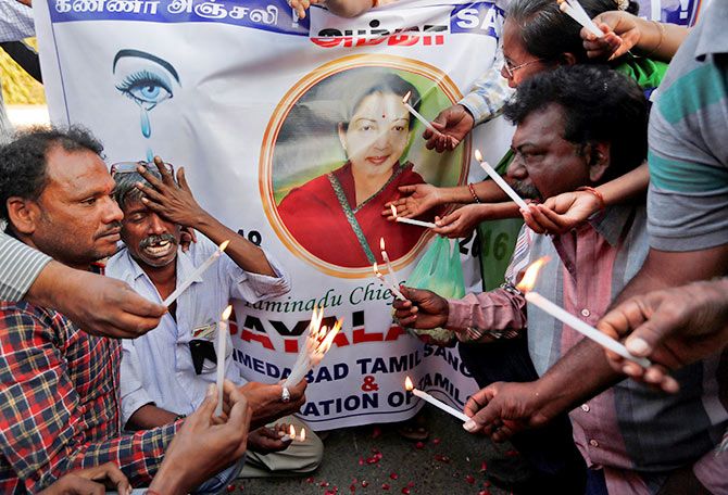  Supporters of Tamil Nadu Chief Minister Jayalalithaa mourn in front of a banner bearing her photograph during a procession in Ahmedabad, on December 6, 2016. 