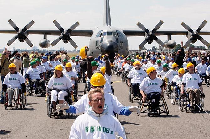 People in wheelchairs pull a C130 cargo aircraft weighing 67 tons across 100 metres at the Melsbroek military airport near Brussels May 29, 2011. The attempt, led by 84 people, set a new Guinness World Record for heaviest plane pulled over 100 metres by a team of people in wheelchairs. Photo: Sebastien Pirlet/ReutersTERS/