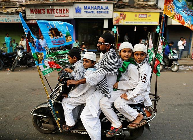 Muslims ride on a scooter on their way to participate in a procession to mark Eid-e-Milad-ul-Nabi