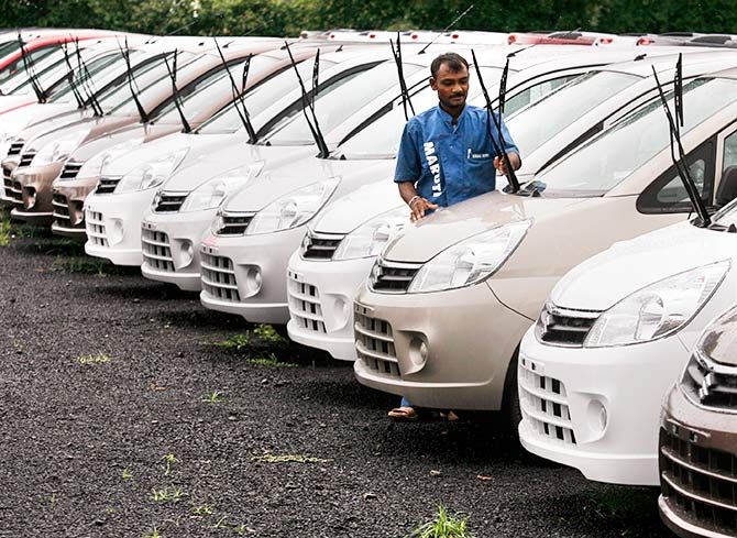 An employee works beside parked cars at the Maruti Suzuki's stockyard on the outskirts of the western Indian city of Ahmedabad July 24, 2010. Photo: Amit Dave/Reuters