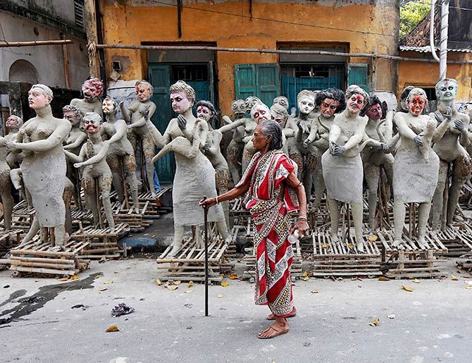 A woman walks past semi-finished clay idols of the Hindu mythological characters 'Dakinis' and 'Yoginis', who will be worshipped along with the Hindu goddess Kali, at a roadside workshop ahead of the Kali Puja festival in Kolkata, India. Photo: Rupak De Chowdhuri /Reuters