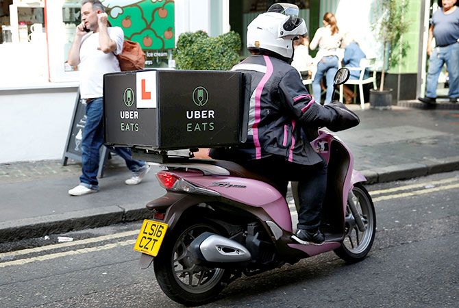 An UberEATS food delivery courier rides her scooter in London, Britain September 7, 2016. Picture taken September 7, 2016. Photo: Neil Hall/Reuters