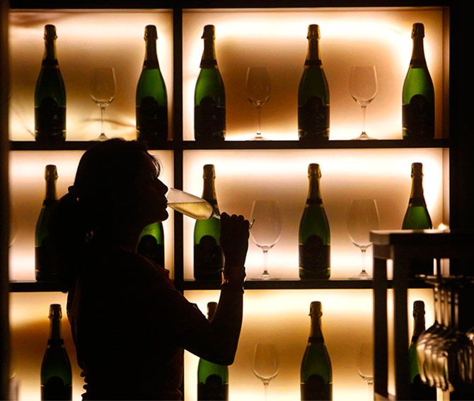 A woman poses with a glass of wine at a tapas bar in Mumbai March 9, 2013. Picture taken March 9, 2013. Photo: Vivek Prakash/Reuters