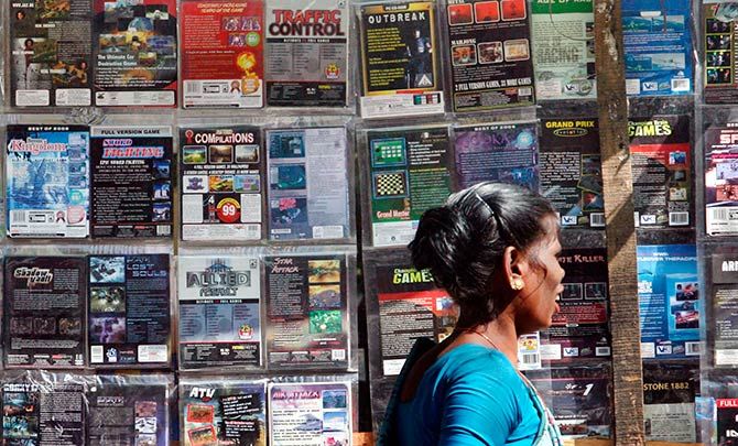 A woman walks past pirated DVDs and software on sale at a street side hawker shop in Mumbai November 12, 2009. Photo: Arko Datta/Reuters