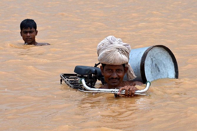 Still riding using a cycle during a flood at Maner, Patna district, Bihar. Photograph: Krishna Murari Kishan/Reuters.