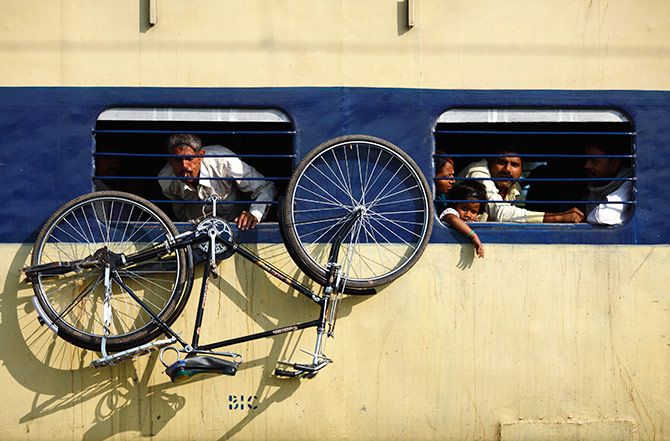 A bicycle hangs from the window of a train at Parsha Bazar railway station, Patna, Bihar. Photograph: Navesh Chitrakar/Reuters.