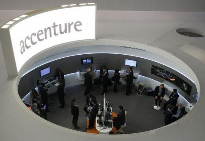 Visitors look at devices at Accenture stand at the Mobile World Congress in Barcelona, February 26, 2013