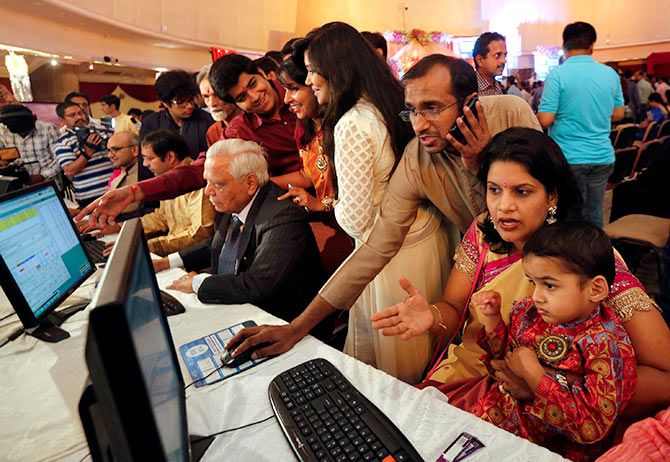 A stockbroker trades as his family watches during the Diwali special trading session celebrating the annual Hindu festival of lights at the Bombay Stock Exchange (BSE) in Mumbai October 23, 2014. Indian shares rose in a special "muhurat" trading session for Diwali on Thursday, led by gains in Suzlon Energy Ltd. while hopes for continued foreign fund inflows into the country also boosted sentiment. Photograph: Shailesh Andrade/Reuters.