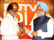 Rajnikanth receives the NDTV Indian award from Prime Minister Manmohan Singh