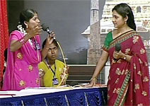 A woman speaks up as Rohini looks on