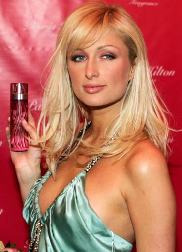 Paris Hilton poses with her new perfume outside a night club in Paris.