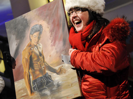 A fan holds a painting of SRK