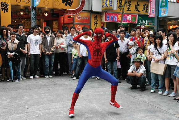 A man dressed as Spider-Man dances to promote a Spider-Man film