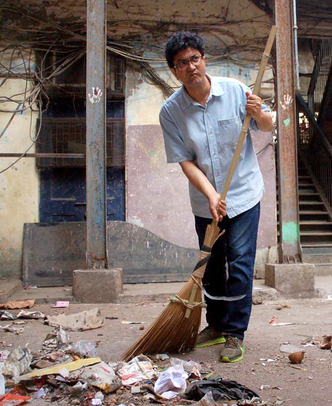 Prasoon Joshi cleans the streets outside the Sofi Mahal building in Lalbaug, South Mumbai, as part of Prime Minister Narendra Modi's Swachh Bharat Abhiyan. Photograph: Sahil Salvi