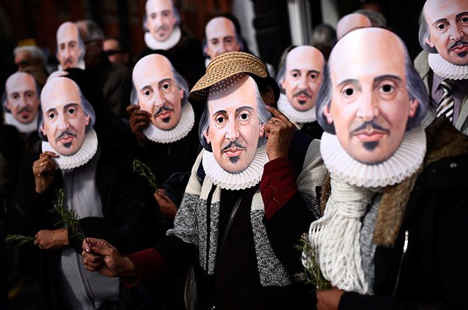 People hold up face masks with William Shakespeare's portrait during celebrations to mark the 400th anniversary of the playwright's death in the city of his birth, Stratford-Upon-Avon