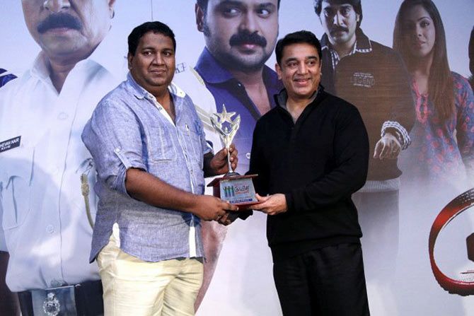 Rajesh Pillai receives an award from Kamal Haasan
