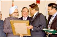 President Musharraf (R) presents a picture to Prime Minister Manmohan Singh