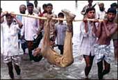 Villagers with the body of a Border Security Force soldier killed during clashes with the Bangladesh Rifles