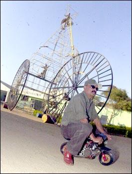 K Sudhakar poses with the world's biggest bicycle is in the background