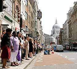 Office workers line the kerb in London's Fleet Street  July 14 during a two minute silence held across Britain in memory of the victims of last week's bomb atttacks In the  background is the dome of St.Paul's Cathedral.(AP Photo/Dimitri Messinis)