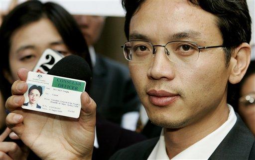 Chinese diplomat Chen Yonglin  holds up his Chinese consular identity card to the media at a rally to commemorate the June 4, 1989 crackdown on the Tiananmen Square pro-democracy protests in Beijing,  in Sydney, Australia, Saturday, June 4. Chen is seeking political asylum in Australia  (AP Photo/Mark Baker)