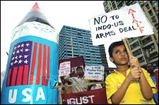 An schoolboy displays a placard hostile to a recent Indian-US nuclear deal next to a mock nuclear bomb during an anti-nuclear protest in Kolkata, August 6, 2005. Deshakalyan Chowdhury/AFP/Getty Images)
